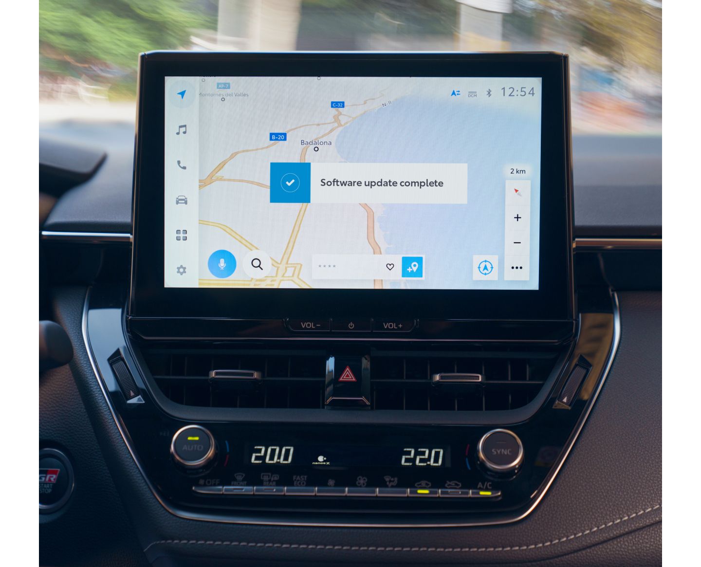 Nahaufnahme eines Multimediageräts auf dessen Bildschirm die Navigation angezeigt wird mit einer Bestätigung, dass ein Update gemacht wurde.