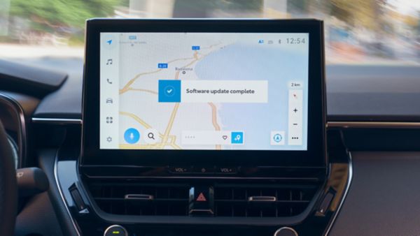 Nahaufnahme eines Multimediageräts auf dessen Bildschirm die Navigation angezeigt wird mit einer Bestätigung, dass ein Update gemacht wurde..