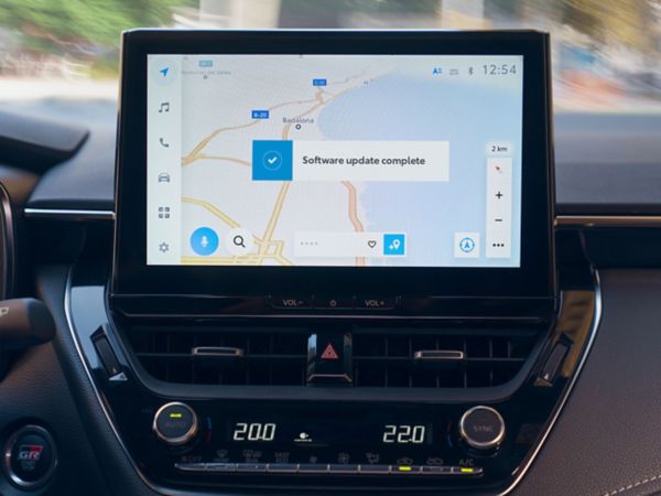Nahaufnahme eines Multimediageräts auf dessen Bildschirm die Navigation angezeigt wird mit einer Bestätigung, dass ein Update gemacht wurde..