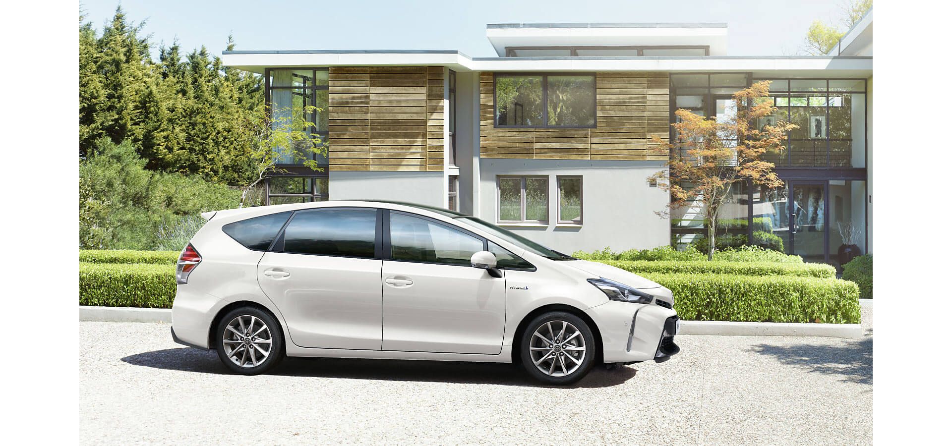 Toyota Prius+ parked by a house