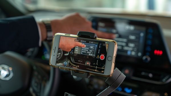 Toyota showroom video of a phone on a holder in a car