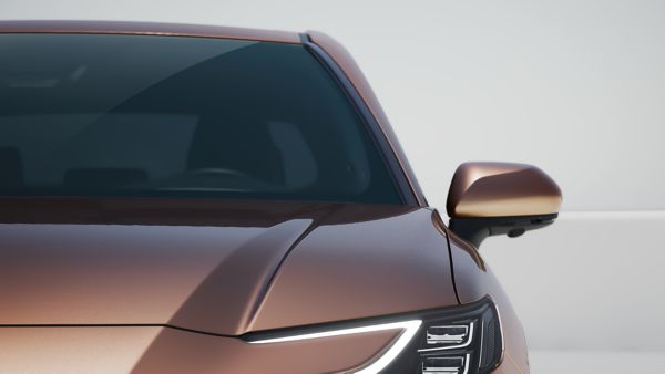 Seitlich-frontale Nahaufnahme der Windschutzscheibe eines bräunlichen Toyota vor einem neutralen grauen Hintergrund.