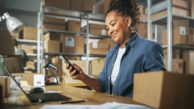 Woman browsing phone in warehouse