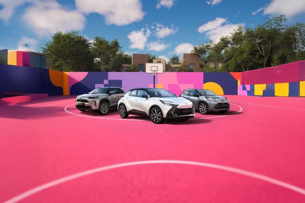 Drei Fahrzeuge von Toyota stehen auf einem pinken Basketballfeld. Die Wände sind in bunten Formen dekoriert.