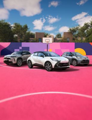 Drei Fahrzeuge von Toyota stehen auf einem pinken Basketballfeld. Die Wände sind in bunten Formen dekoriert.