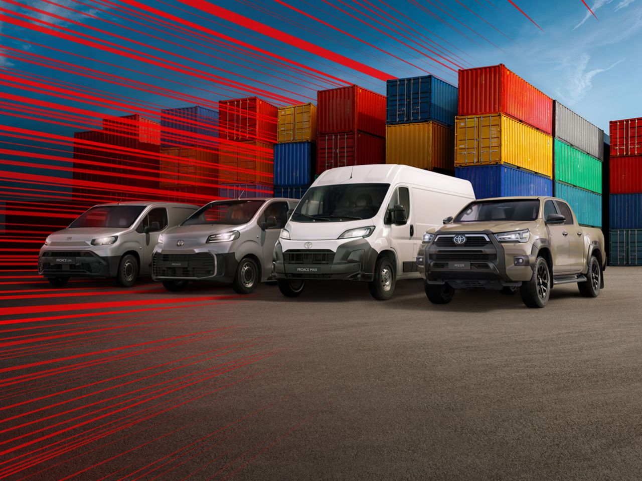 Vier Nutzfahrzeuge von Toyota stehen vor bunten Containern auf einer freien Asphaltfläche