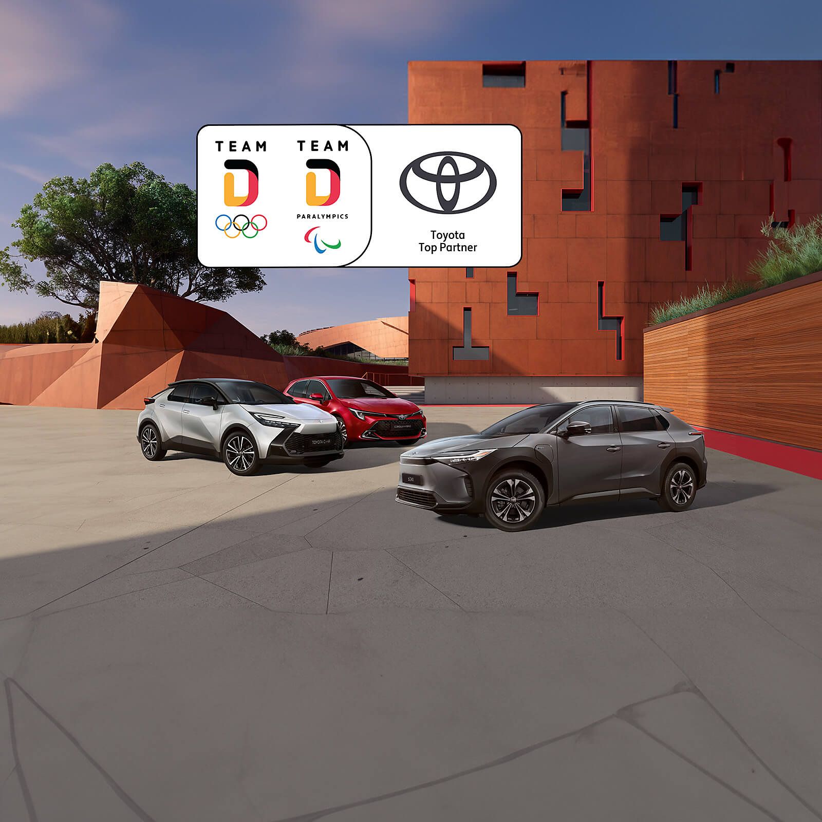 Toyota Team Deutschland Modelle stehen vor einem roten Gebäude