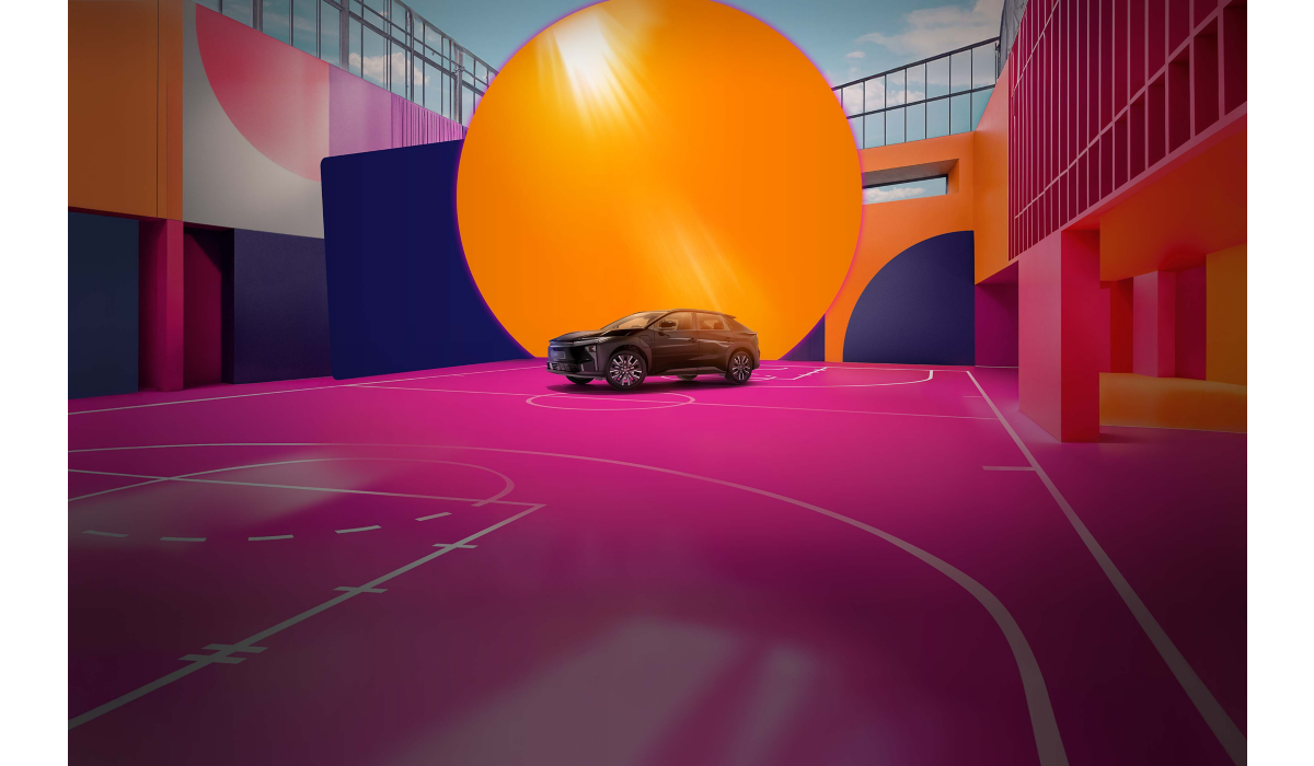 Ein Fahrzeug von Toyota steht auf einem pinken Basketballfeld vor einer orangenen Kugel. Die Wände sind in bunten Formen bemalt.
