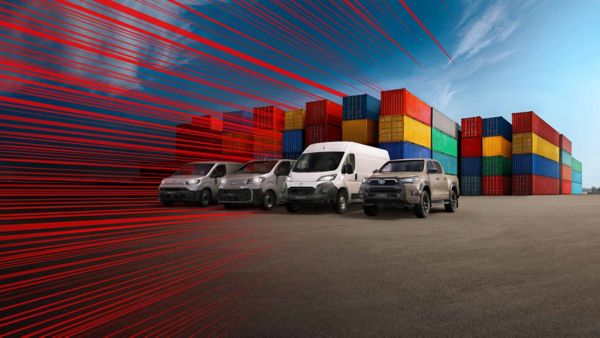 Vier Toyota Nutzfahrzeuge stehen vor einer bunten Wand aus Containern, bereit für ihre Aufgabe