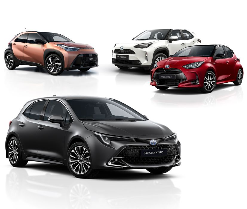 Drei Fahrzeuge - Weißer Aygo X, weißer Yaris Cross und roter Yaris - stehen vor einem neutralen Hintergrund nebeinander aufgereiht. Darunter steht ein schwarzer Corolla