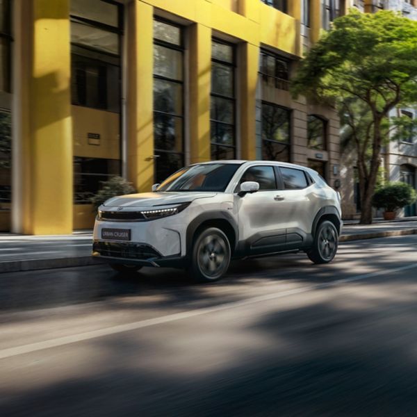 Toyota Urban Cruiser rijdt voor een geel gebouw langs