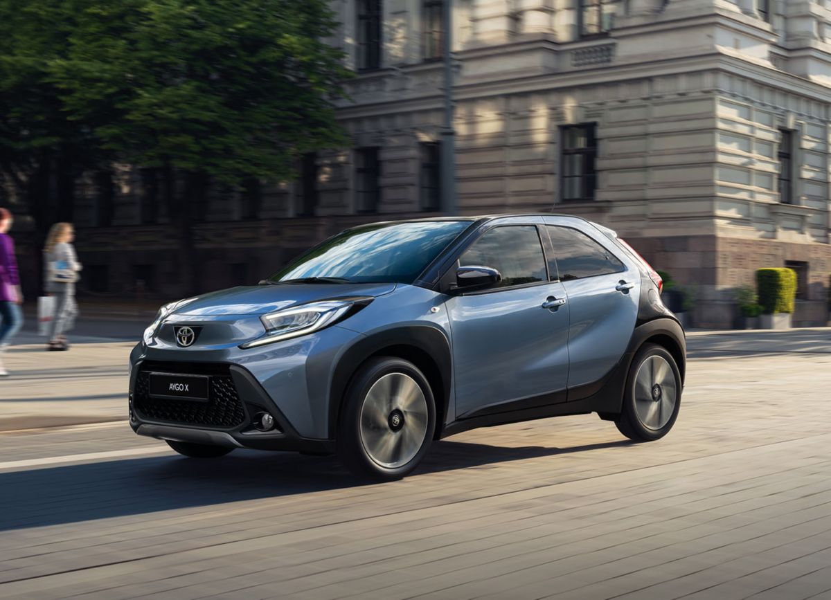 Grauer Toyota Aygo X fährt auf einer Straße in der Stadt