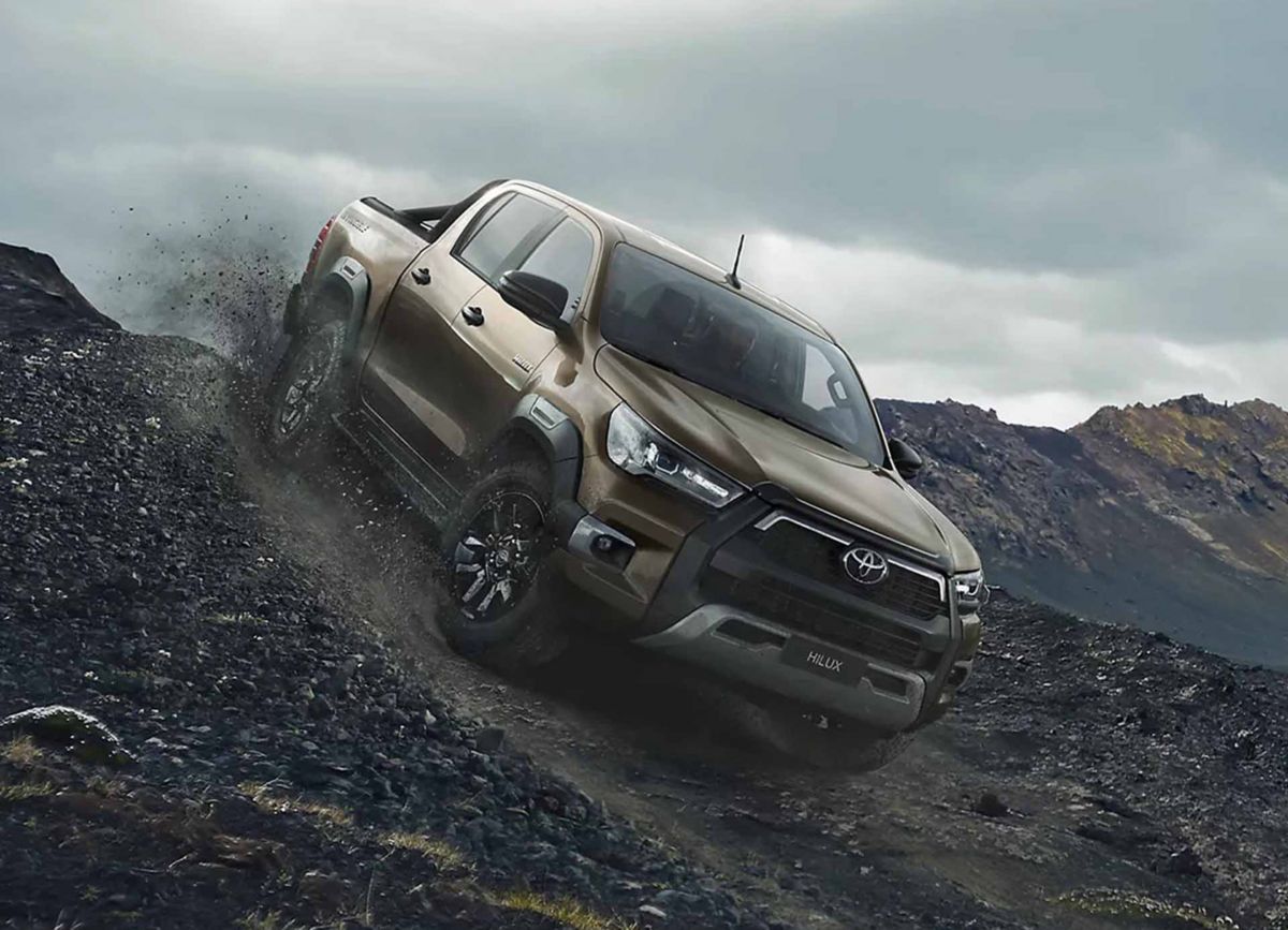 Brauner Toyota Hilux fährt eine felsige Klippe hinunter.