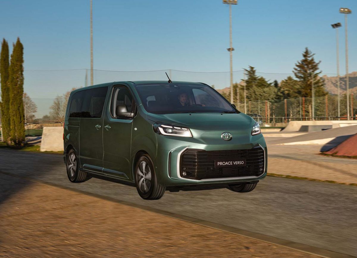 Grüner Proace Verso fährt auf einer schmalen Straße. Im Hintergrund ist ein Skatepark zu sehen.