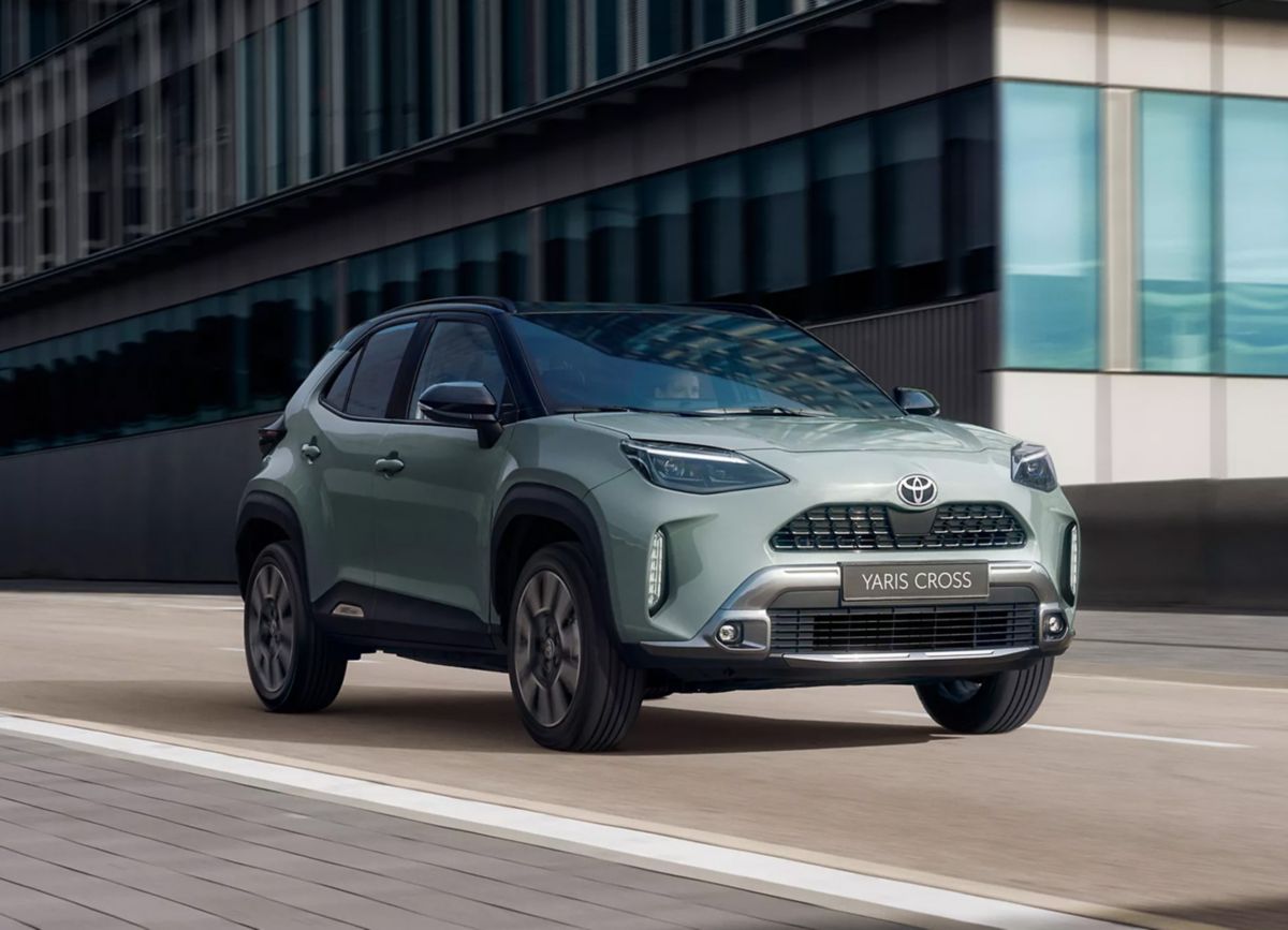 Blauer Toyota Yaris fährt auf einer mehrspurigen Straße in einer Innenstadt.