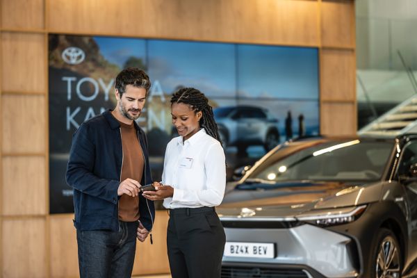 two people looking at a phone inside a Toyota centre