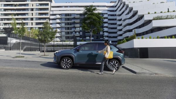 Žena prochází kolem svého vozu Toyota bZ4X.