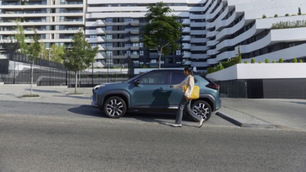 Žena prochází kolem svého vozu Toyota bZ4X.