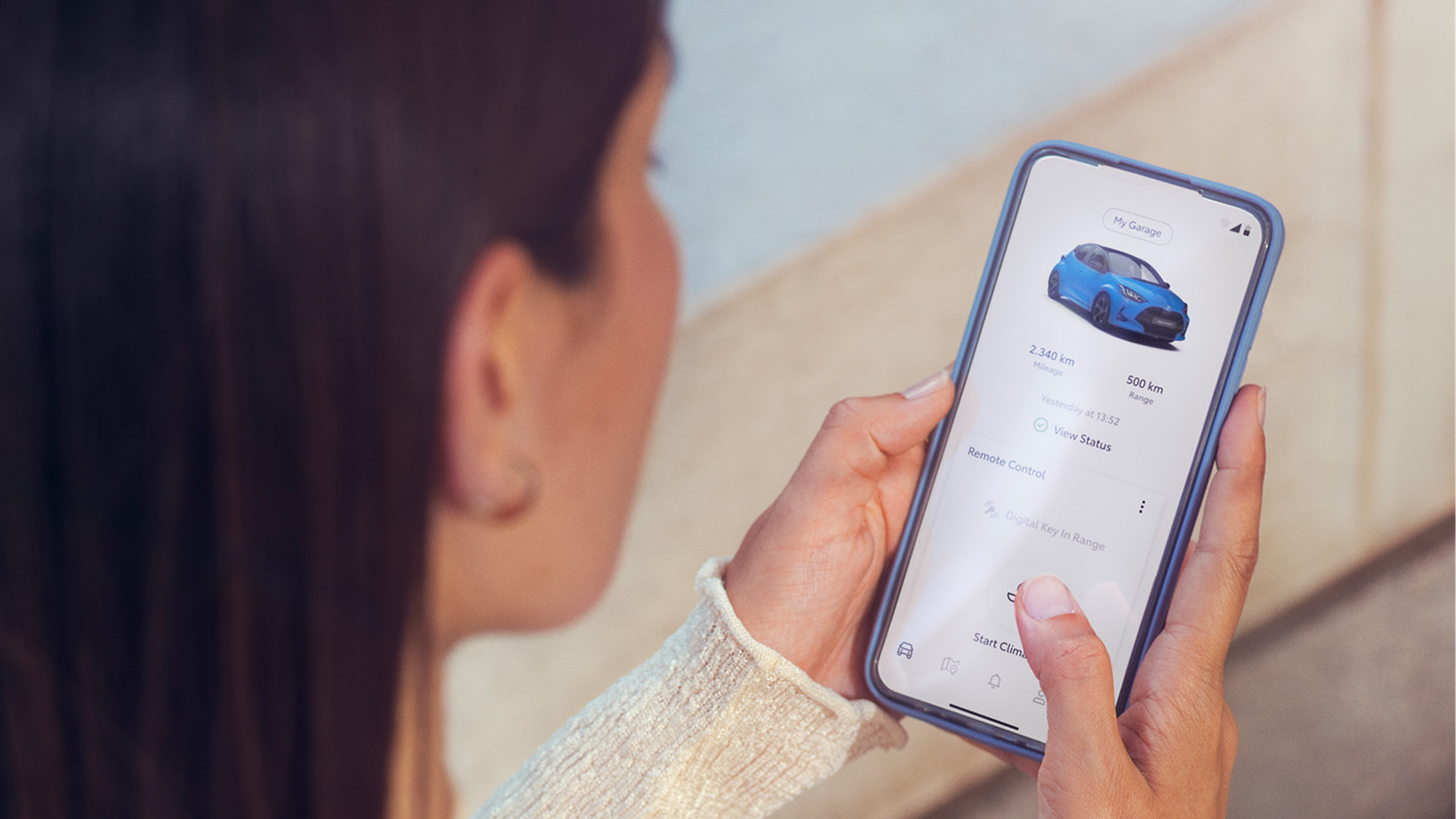 Application MyToyota femme devant son smartphone