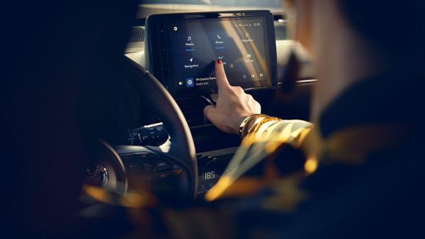 Woman using multimedia screen in Yaris Cross