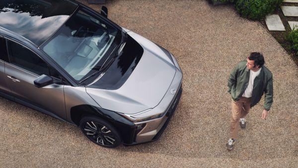 Muž prochází kolem svého vozu Toyota bZ4X.