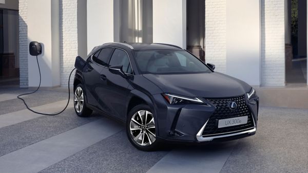 Ein schwarzer Lexus UX300e steht auf einem Platz und wird an einer Lexus Wallbox aufgeladen