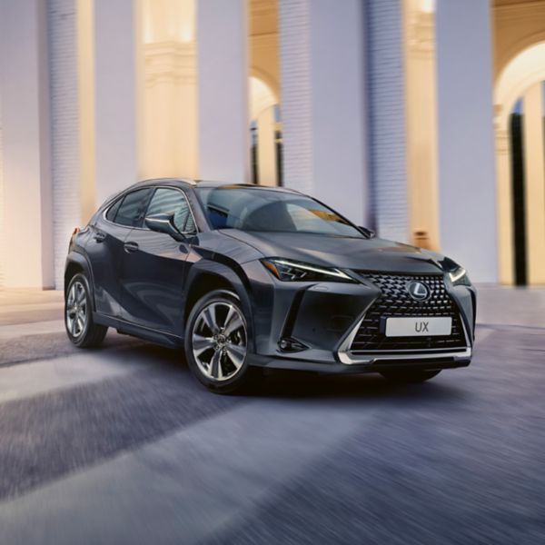 Ein eleganter schwarzer Lexus UX, der in einer stilvollen städtischen Umgebung geparkt ist und sein modernes Design und die Eigenschaften eines kompakten SUVs zur Schau stellt.