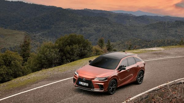 A Lexus RX 450h+ and Lexus RX 500h driving on a road