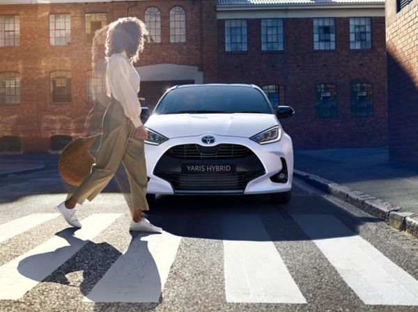 woman walking past Toyota yaris